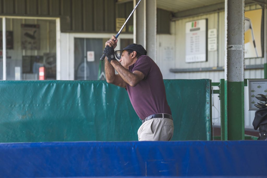 Golfer mid-swing on the range